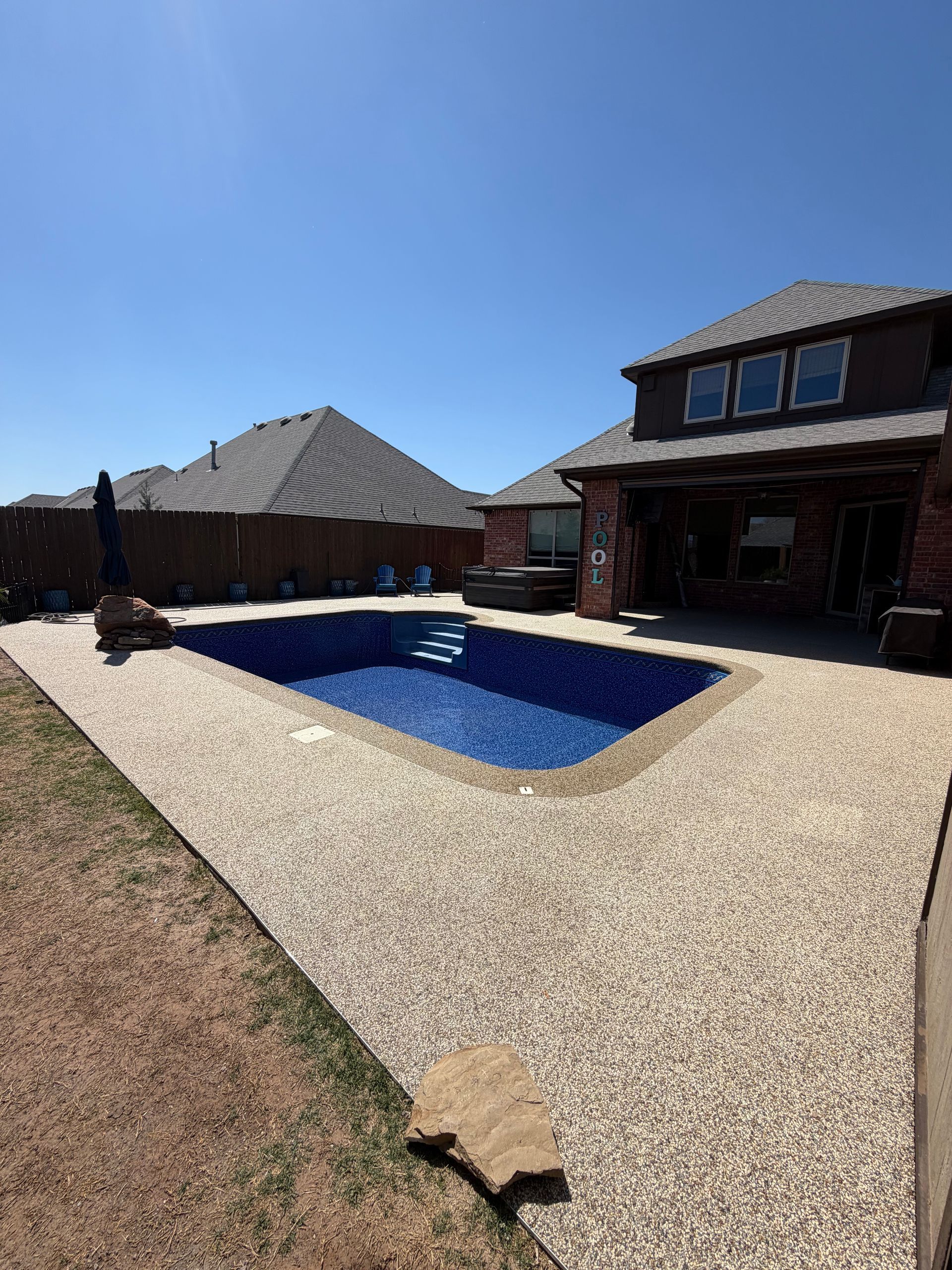 Elite Outdoor Living Solutions installed a custom stone fire pit with surrounding patio seating in Heritage Hills, OKC.