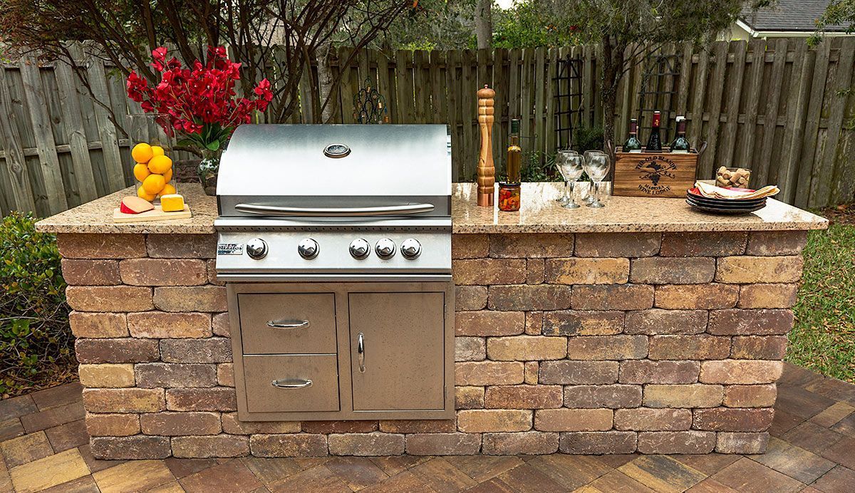 Elite Outdoor Living Solutions installed a brick outdoor kitchen island with grill in Quail Creek, OKC.