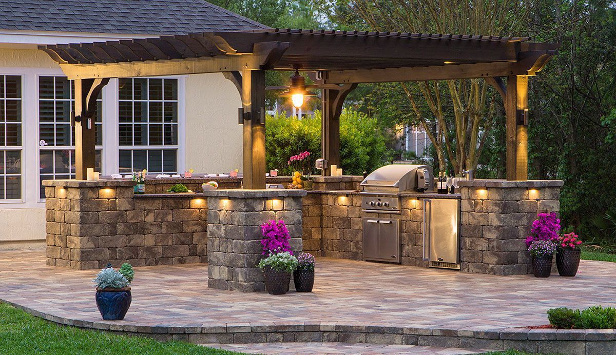 Elite Outdoor Living Solutions installed a patio with a grill and a pergola in front of a house in Bethany, OK.