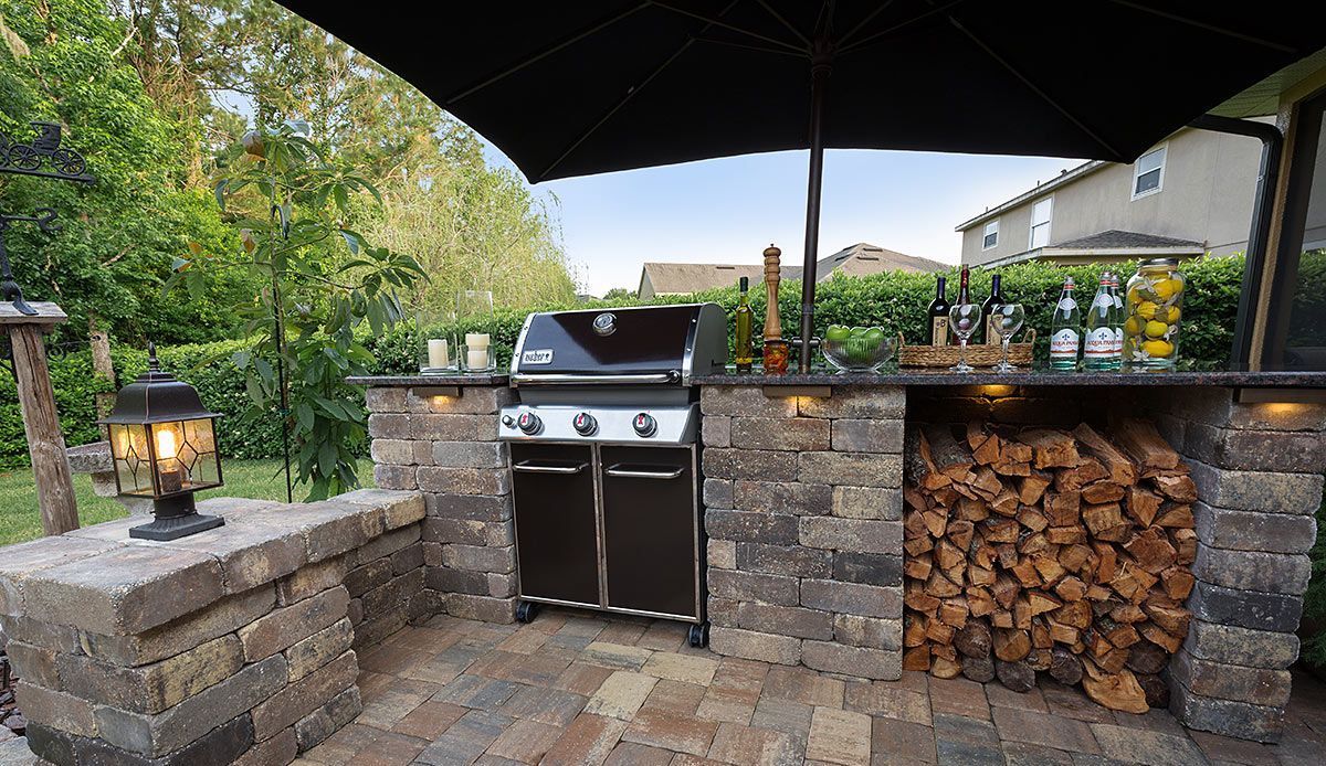 Elite Outdoor Living Solutions built an outdoor backyard grill area under an umbrella in Norman, OK.