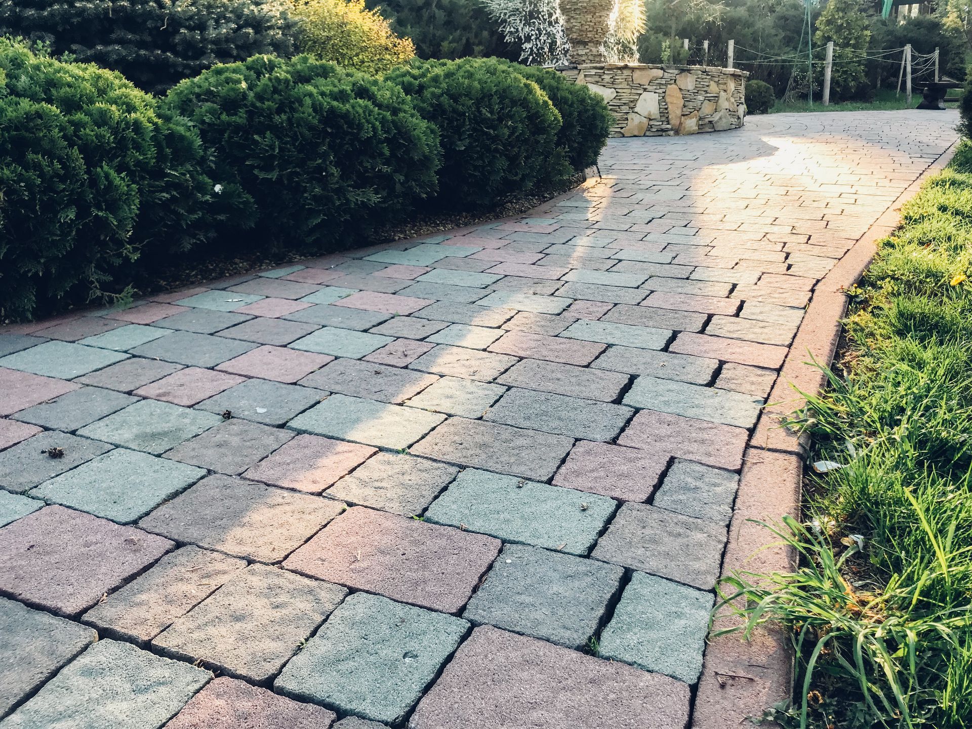 Elite Outdoor Living Solutions installed a brick walkway surrounded by lush bushes in Crown Heights, OKC.