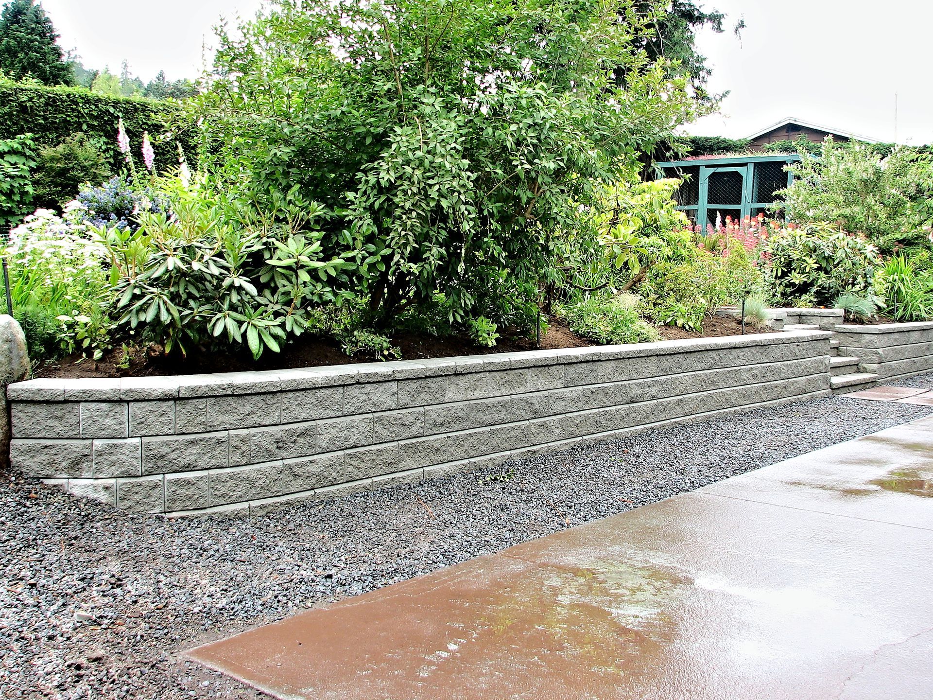 Elite Outdoor Living Solutions is installing a retaining wall using stacked blocks in Mesta Park, OKC.