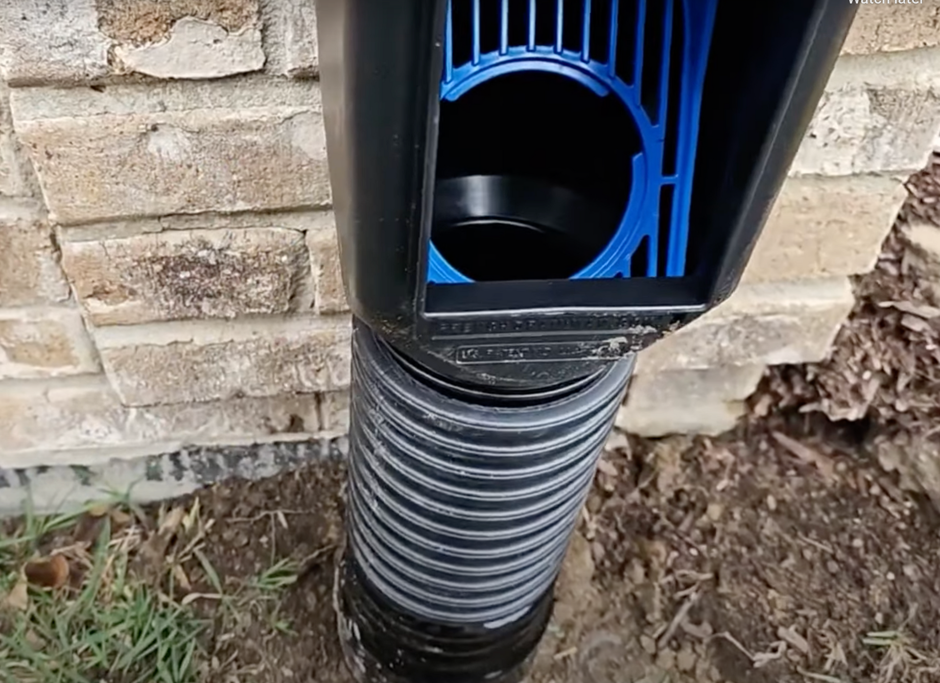 Elite Outdoor Living Solutions installed a black drainage pipe next to a brick wall in Oklahoma City.