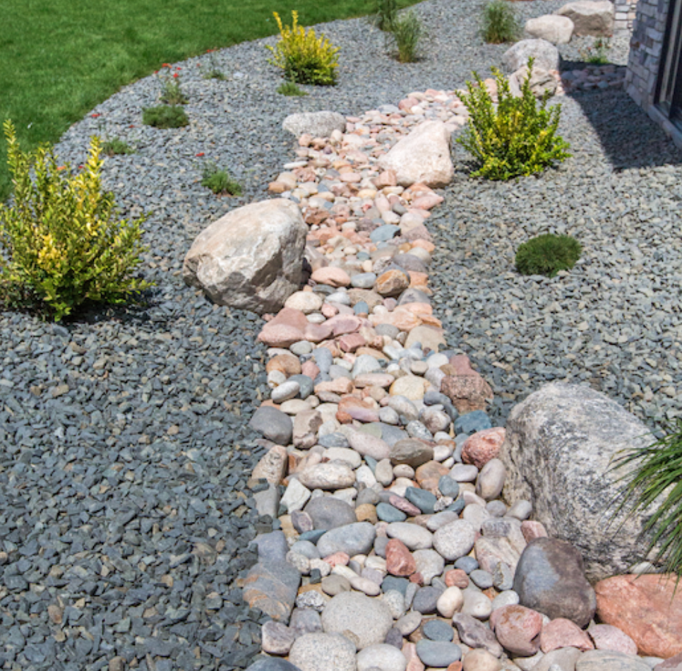 Elite Outdoor Living Solutions installed decorative rock drainage solutions in a garden landscape in Lakehurst, OKC.