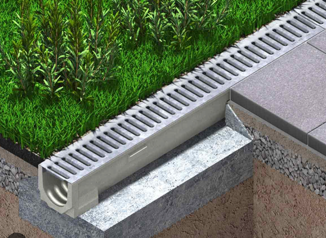 Outdoor Living Solutions is installing a channel drain on top of a concrete surface in The Village, OKC.