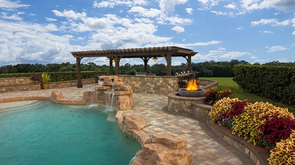Elite Outdoor Living Solutions built a beautiful pool with waterfall and fire pit in The Village, OKC.