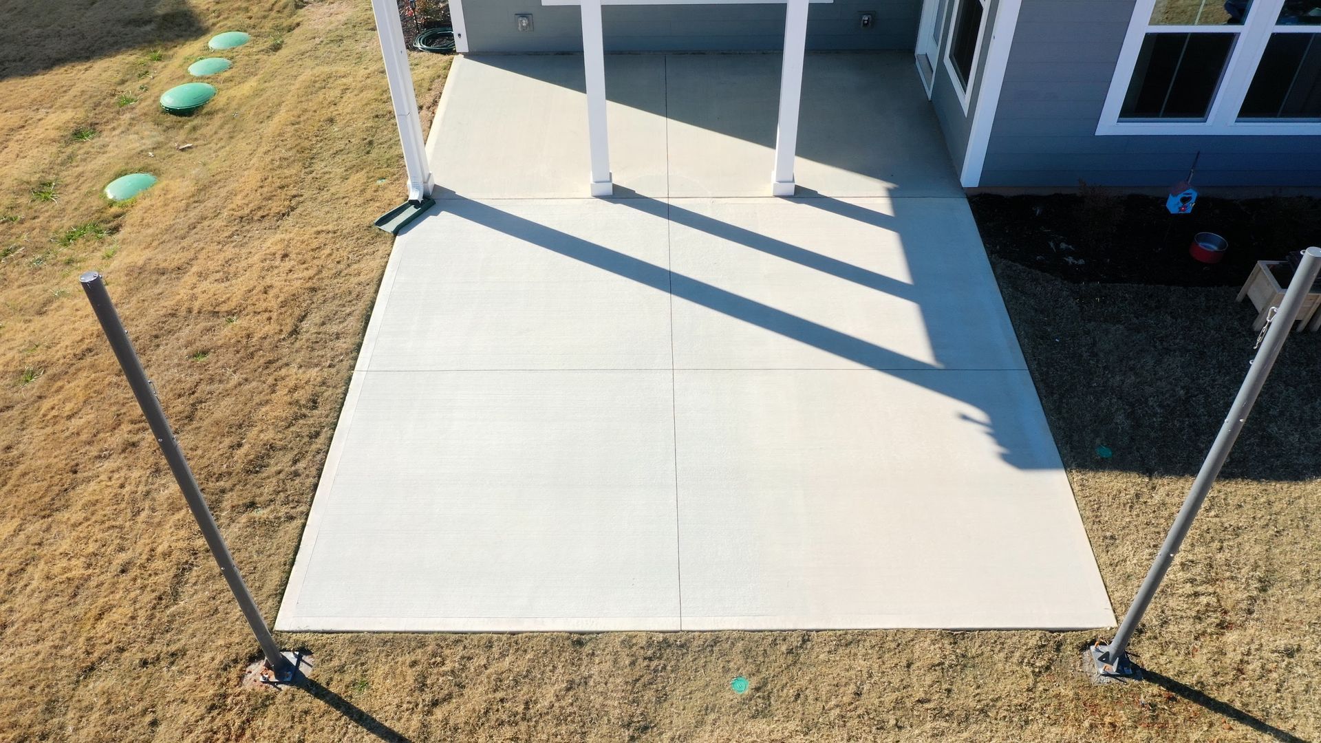 An aerial view of a concrete walkway installed by Elite Outdor Living Solutions leading to a house in Quail Creek, OKC.