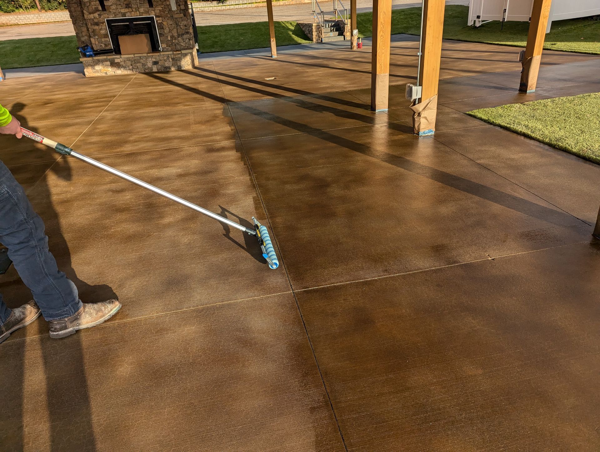 Elite Outdoor Living Solutions installed stained concrete in color brown with a long roller in Oklahoma City.