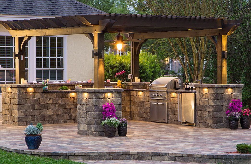 Elite Outdoor Living Solutions created an outdoor kitchen space in Oklahoma City with concrete paving and a pergola.