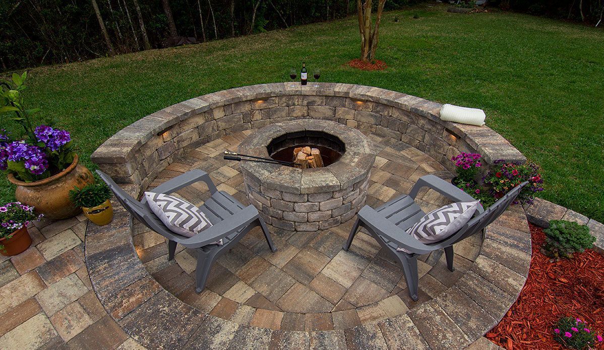 Elite Outdoor Living Solutions built a stunning stone fire pit patio with chairs in Nichols Hills, OKC.