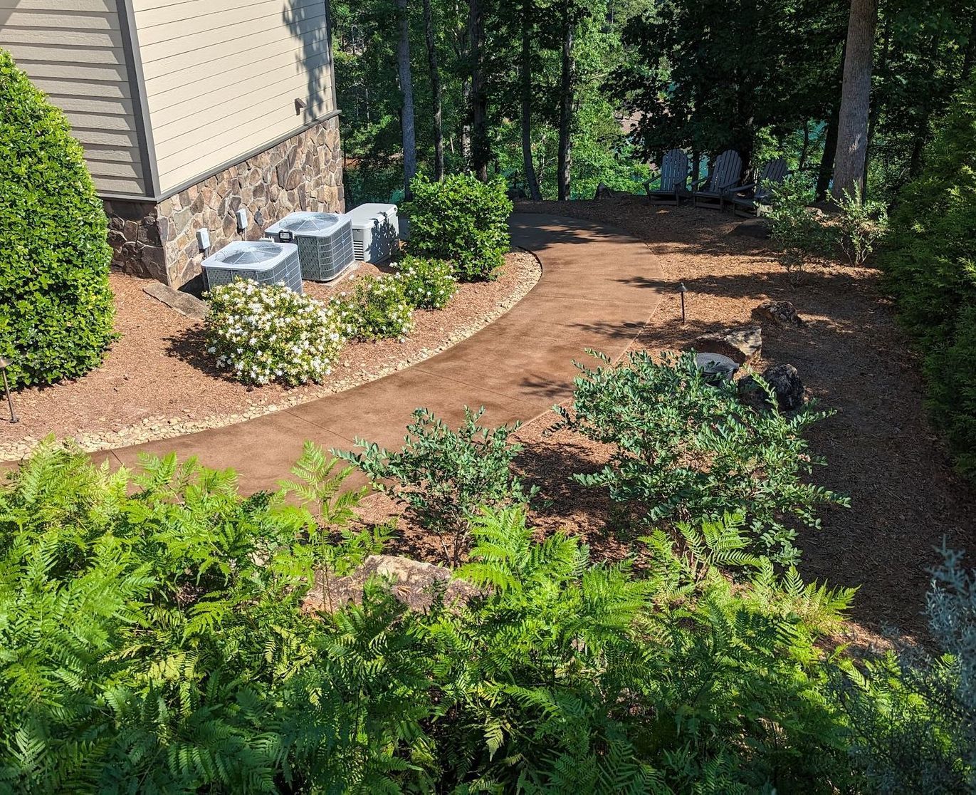 Elite Outdoor Living Solutions stained concrete in a backyard next to lush greenery in Oklahoma City.