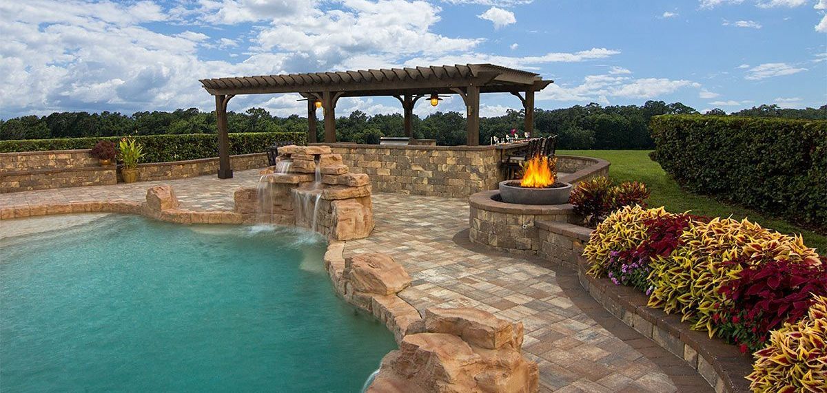 Elite Outdoor Living Solutions completed a swimming pool and fire pit area featuring an elegant pergola in Yukon, OK.