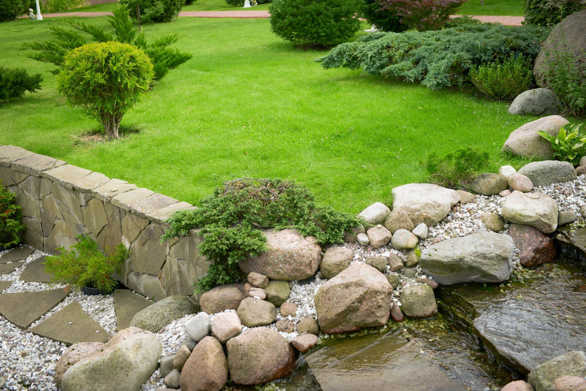 Elite Outdoor Living Solutions built a decorative rock stream for effective water drainage in a garden in Mustang, OK.