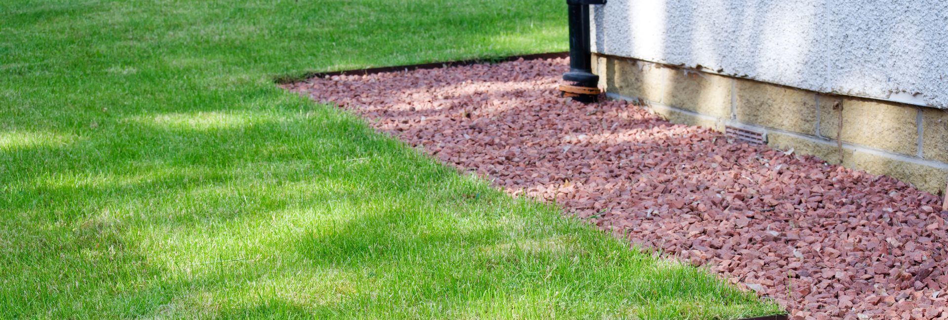 Elite Outdoor Living Solutions installed a functional gravel French drain beside a home in Bethany, OK.