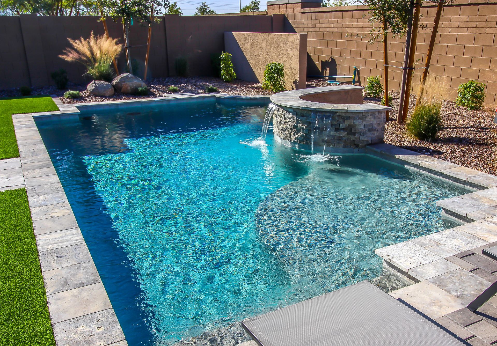  Elite Outdoor Living Solutions is installing a beautiful pool deck with a rock waterfall in Mustang, OK.