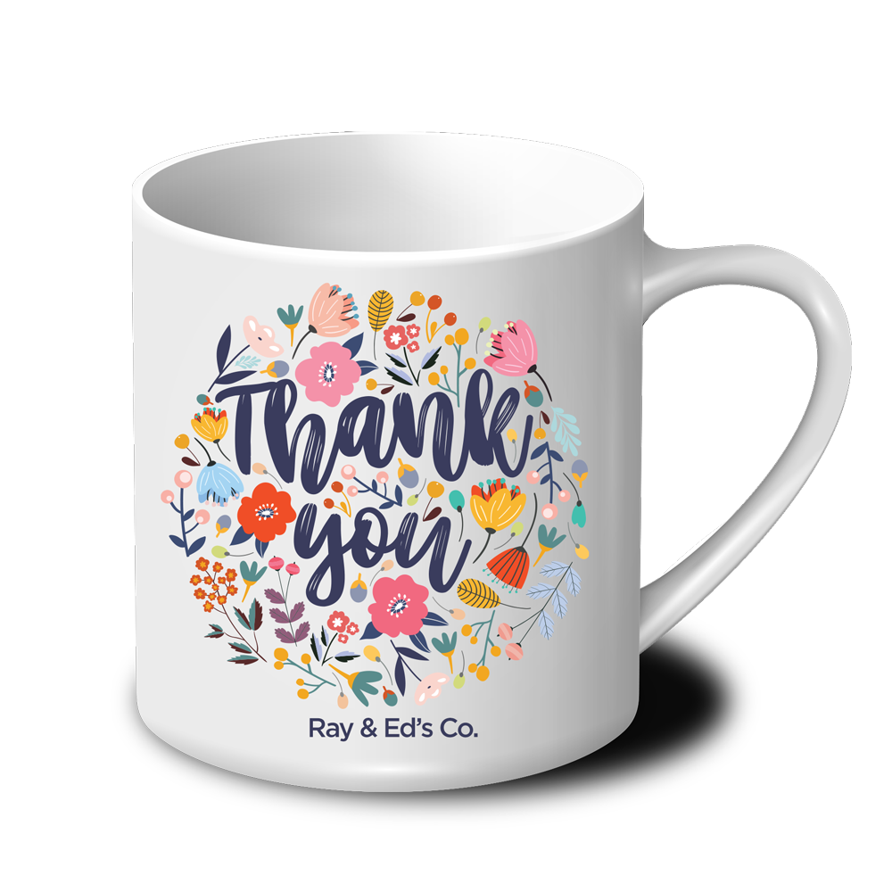 A white coffee mug with the words `` thank you '' surrounded by flowers.