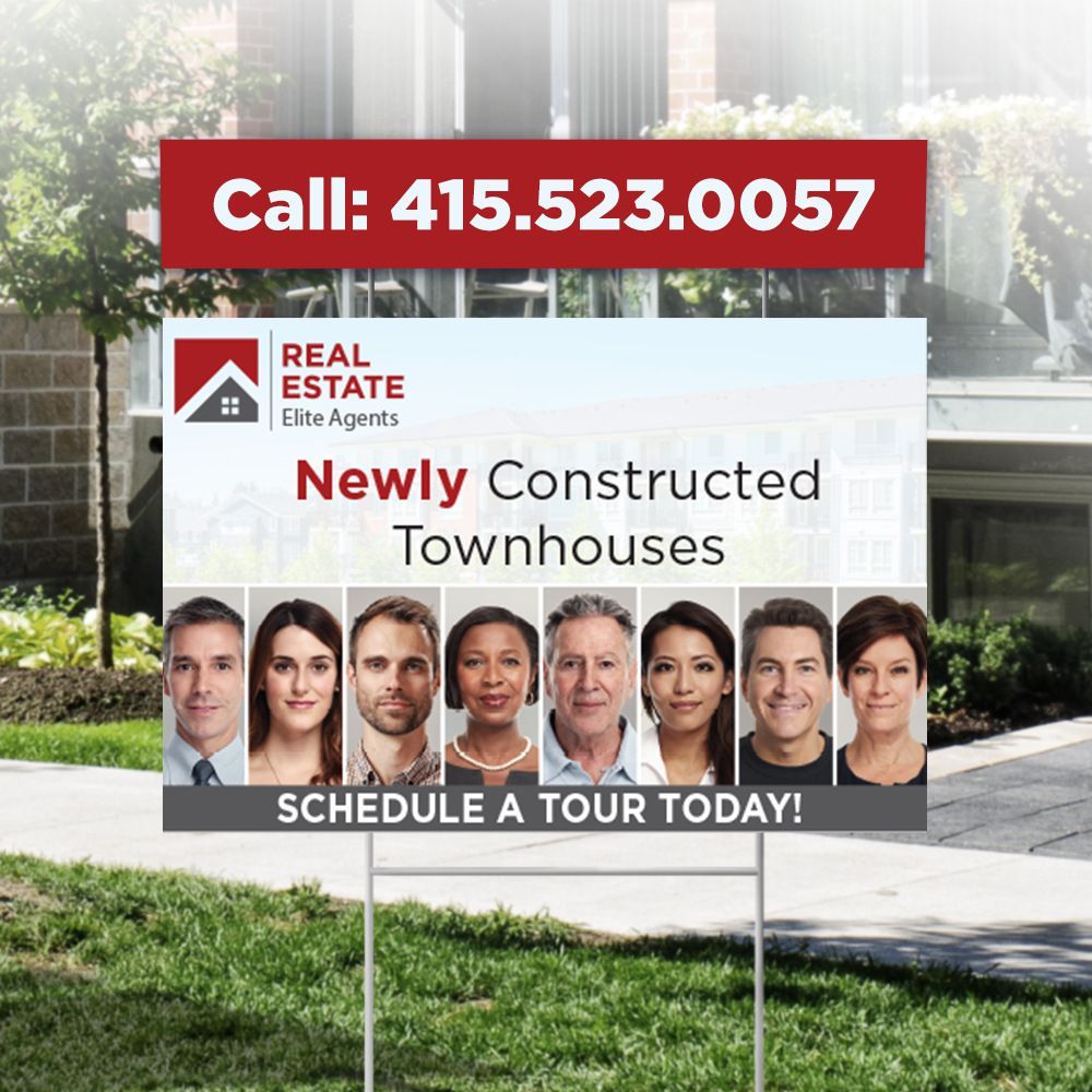 A real estate sign is sitting in front of a house.