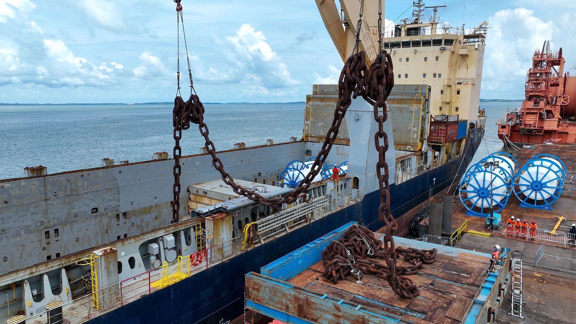 Large shipping changes in blue open top shipping container ready for loading