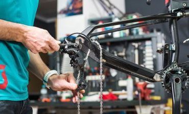 A man is working on a bicycle in a workshop.
