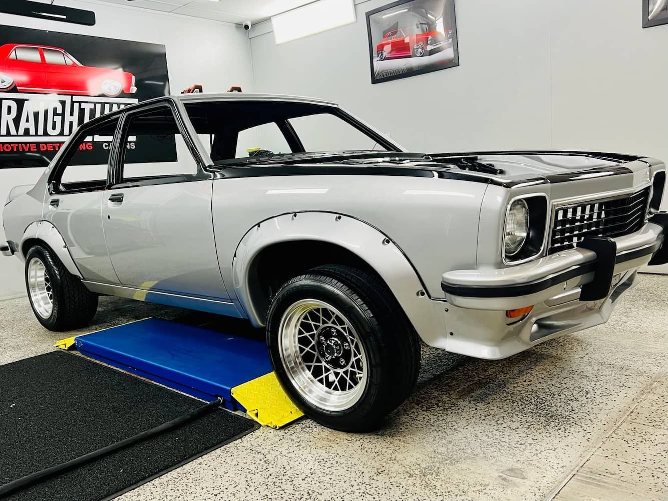 Classic Silver Muscle Car on A Blue Lift in A Garage — Straightline Detailing Cairns in Bungalow, QLD