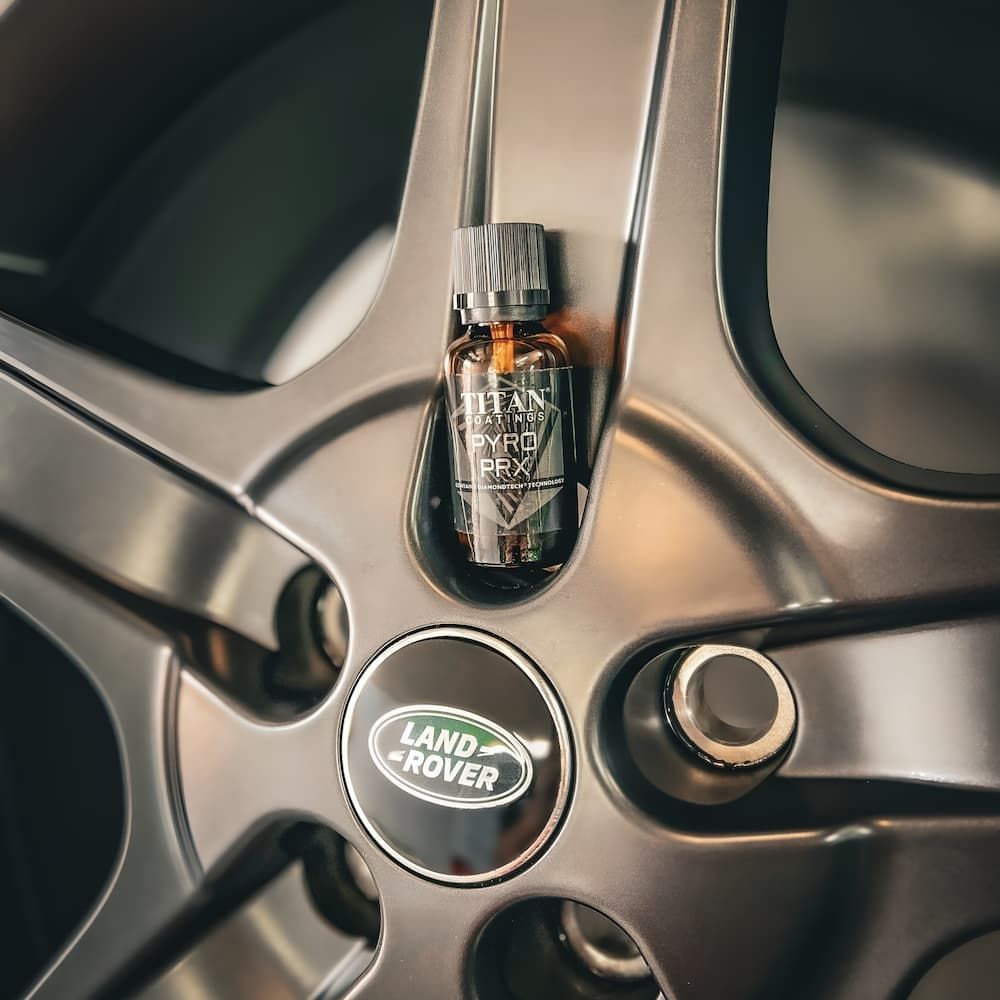 A Bottle of Land Rover Essential Oil is Sitting on a Car Wheel — Straightline Detailing Cairns in Bungalow, QLD