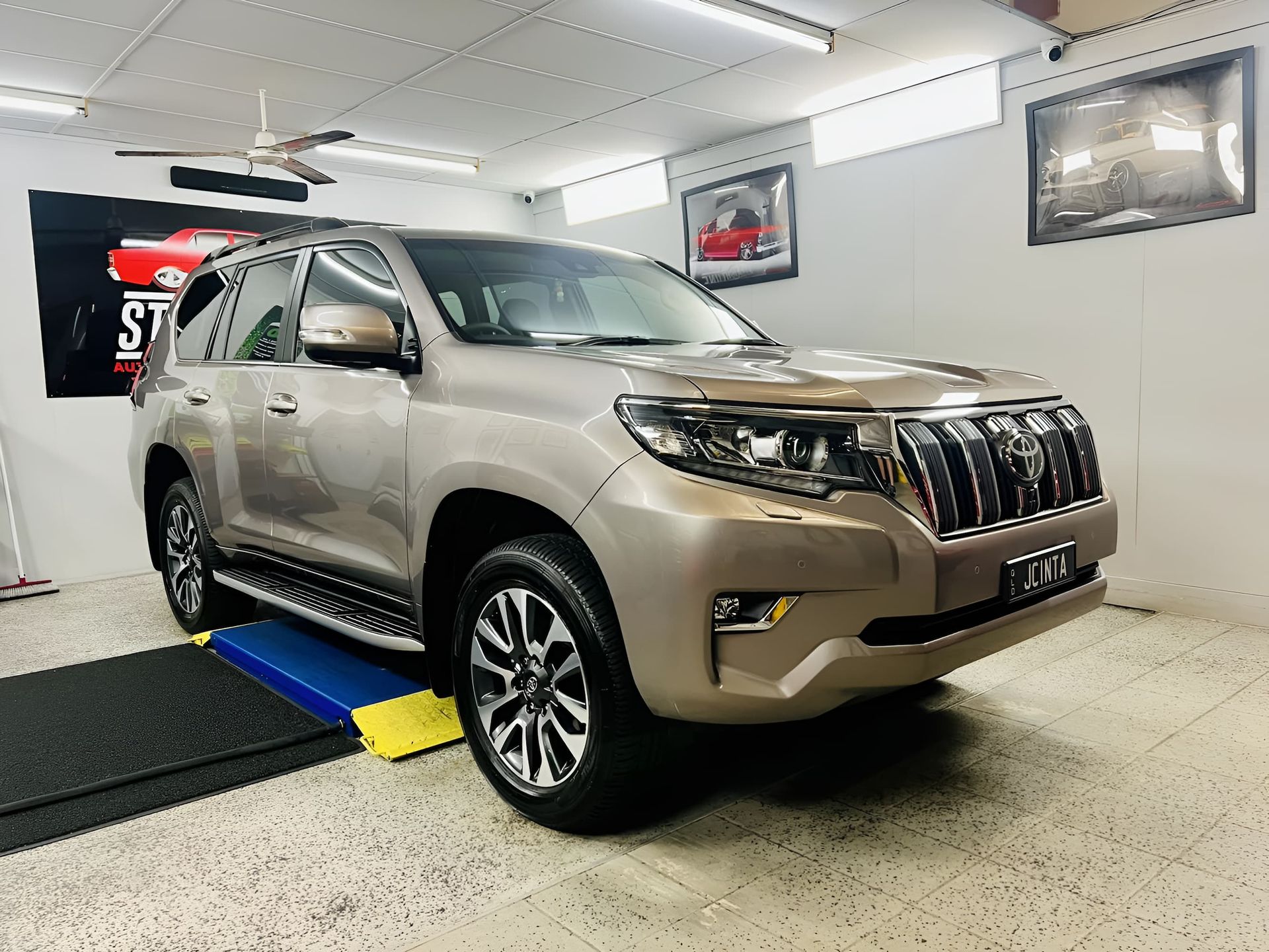 Beige SUV In an Indoor Showroom on A Vehicle Inspection Ramp — Straightline Detailing Cairns in Bungalow, QLD