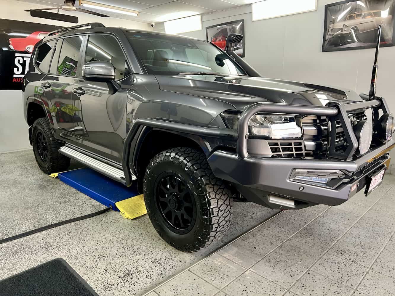 Gray SUV On a Car Lift Inside an Auto Shop — Straightline Detailing Cairns in Bungalow, QLD