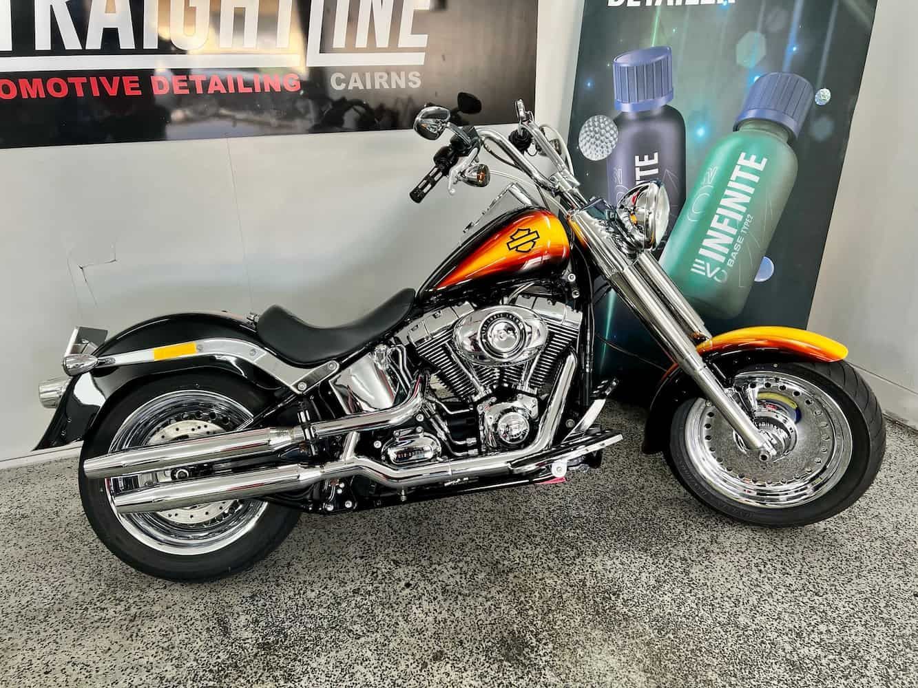 A Motorcycle is Parked in Front of a Sign That Says Infinite Detailing Cairns — Straightline Detailing Cairns in Bungalow, QLD