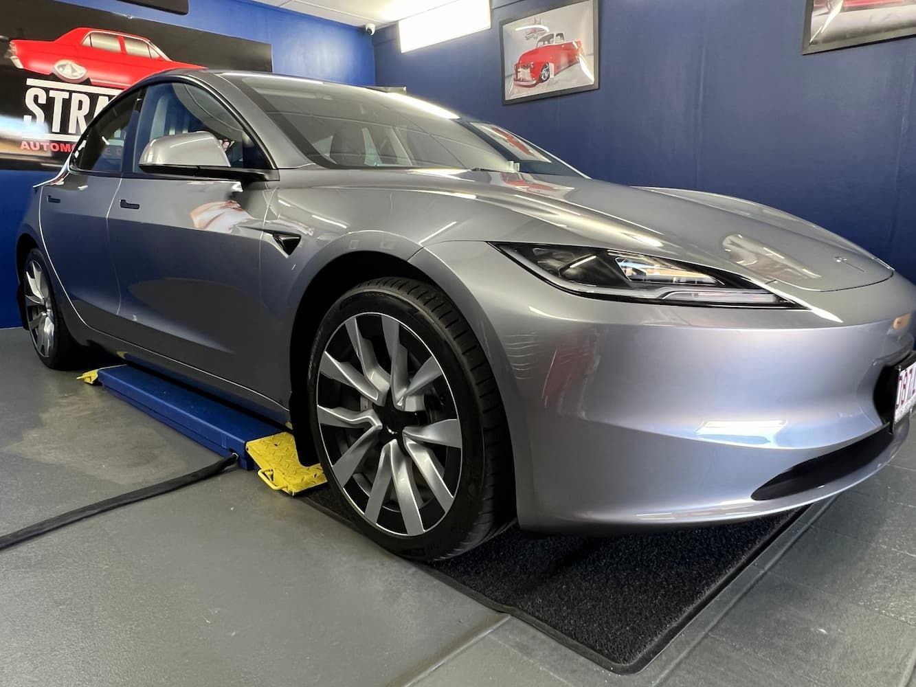 Silver Tesla Sedan in A Garage on A Vehicle Alignment Rack — Straightline Detailing Cairns in Bungalow, QLD