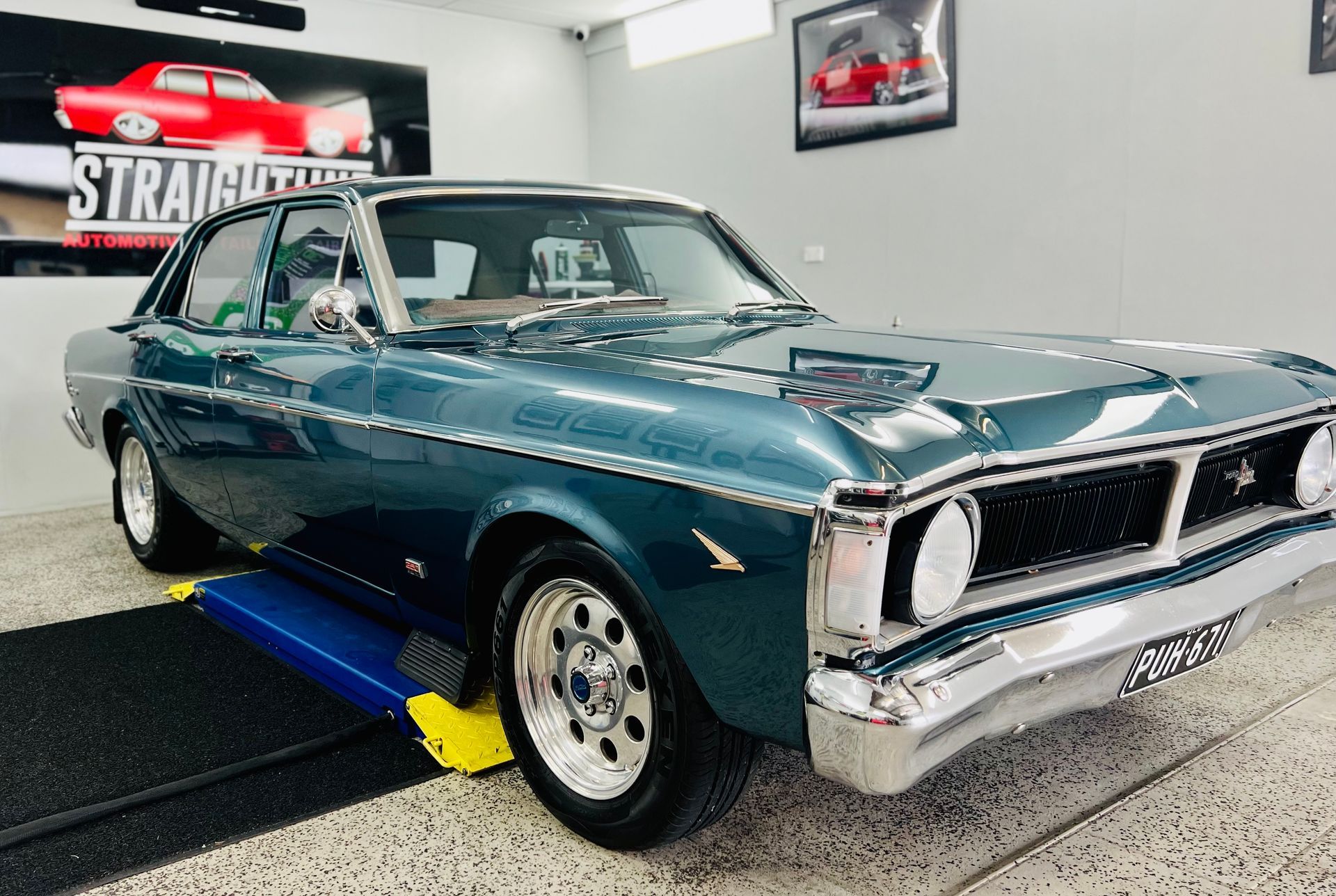 Classic Teal Muscle Car on A Lift in A Garage — Straightline Detailing Cairns in Bungalow, QLD