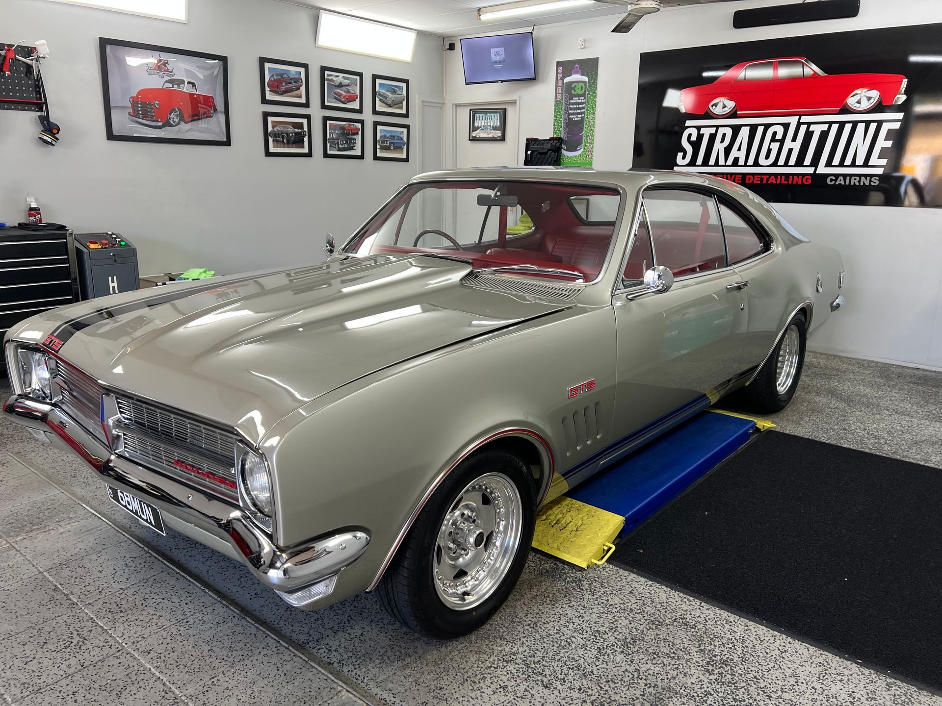 Classic Silver Muscle Car on A Lift in A Garage Showroom — Straightline Detailing Cairns in Bungalow, QLD
