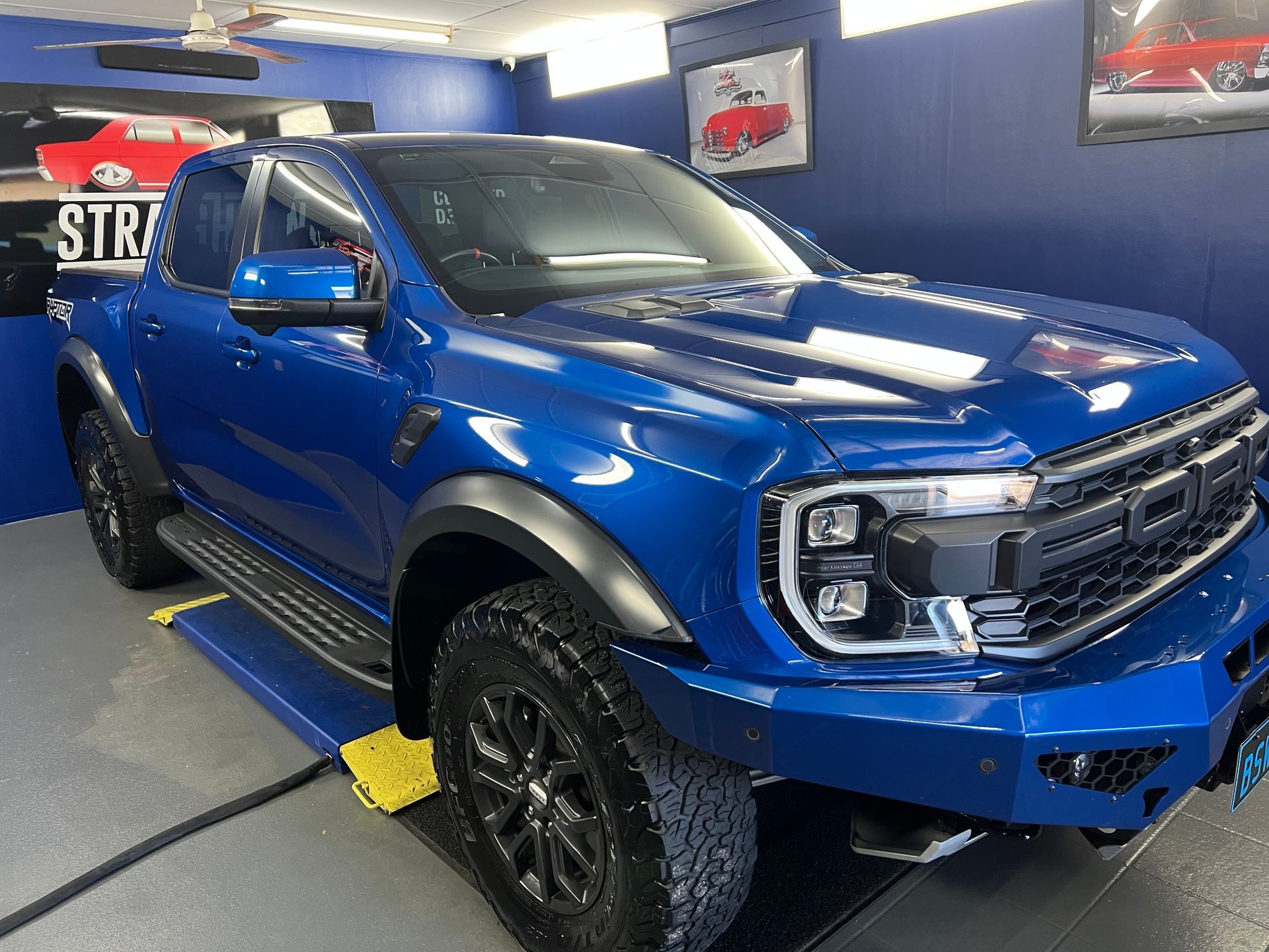 A White Car is Sitting on a Lift in a Garage — Straightline Detailing Cairns in Bungalow, QLD