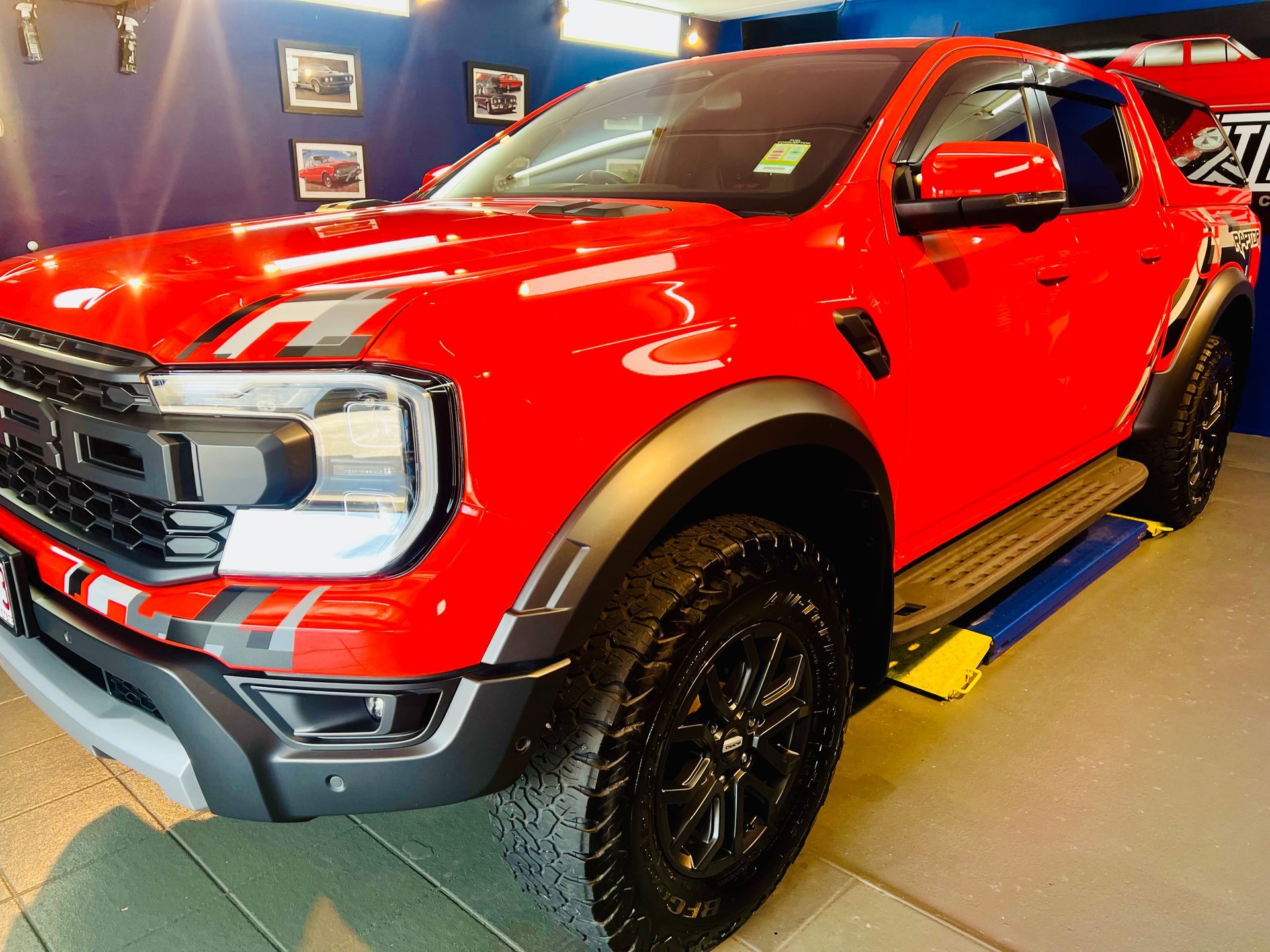 Red Pickup Truck Displayed Indoors on A Blue Floor — Straightline Detailing Cairns in Bungalow, QLD