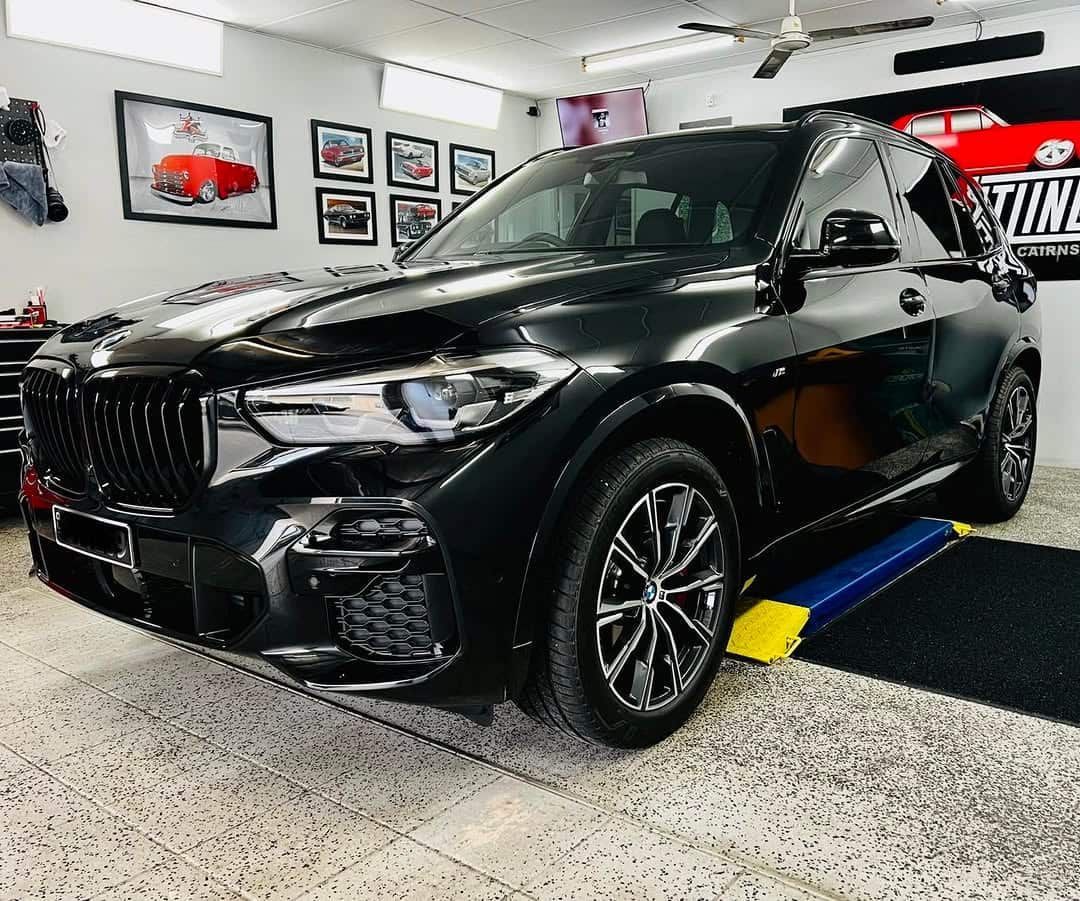 A Black BMW X5 is Parked in a Garage — Straightline Detailing Cairns in Bungalow, QLD