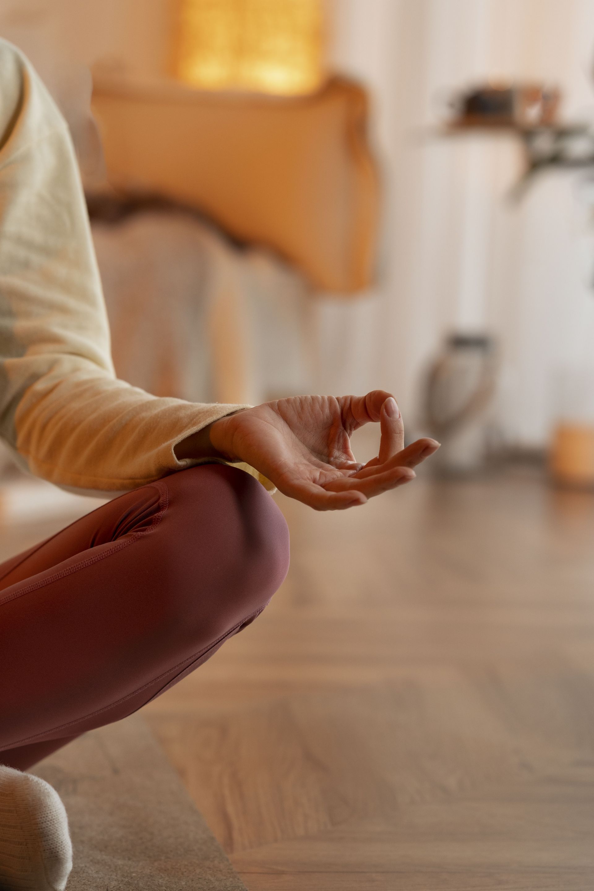 a woman sits on the floor with her legs crossed and her hands in a lotus position
