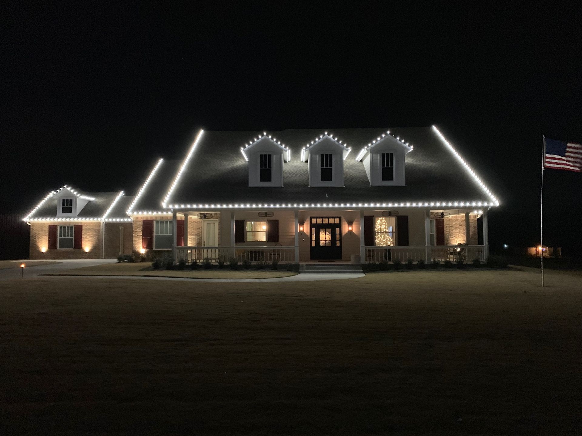 white house with white christmas lights on dormers
