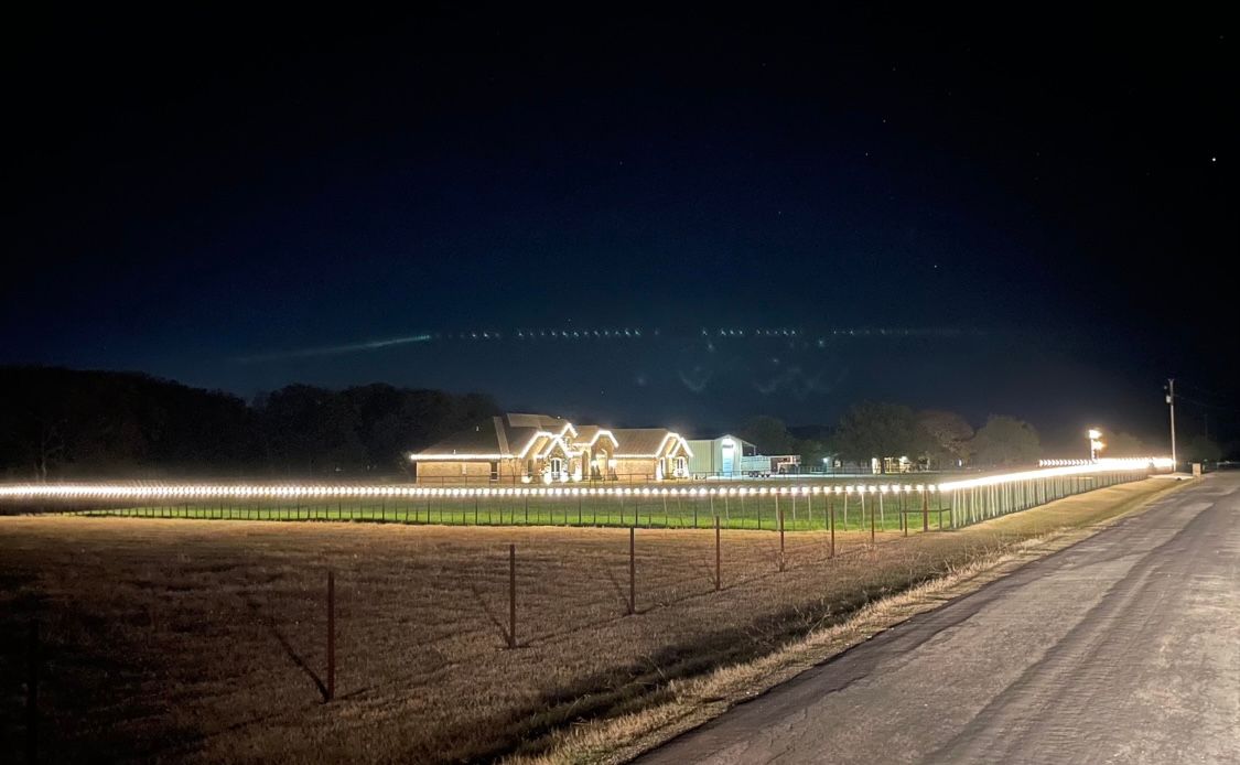 country home with white christmas lights on fence