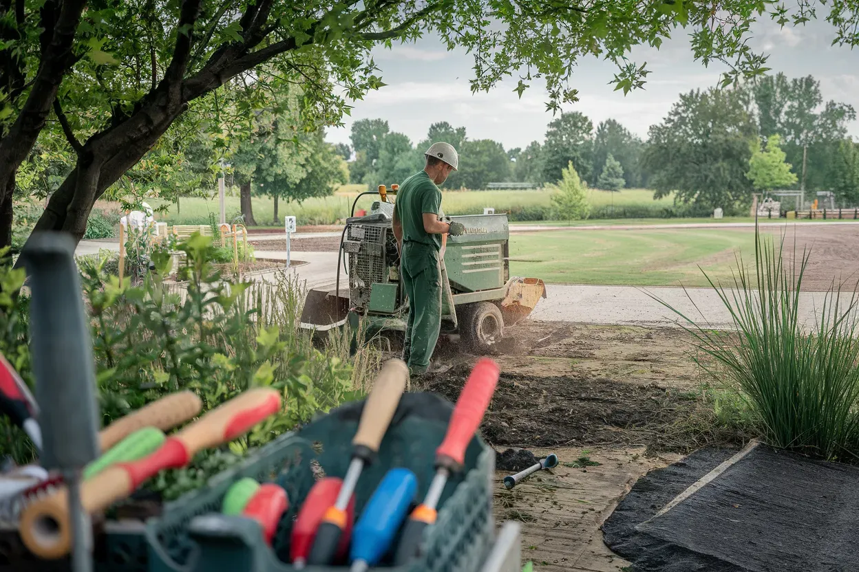 A man is using a tractor to dig a hole in the ground.