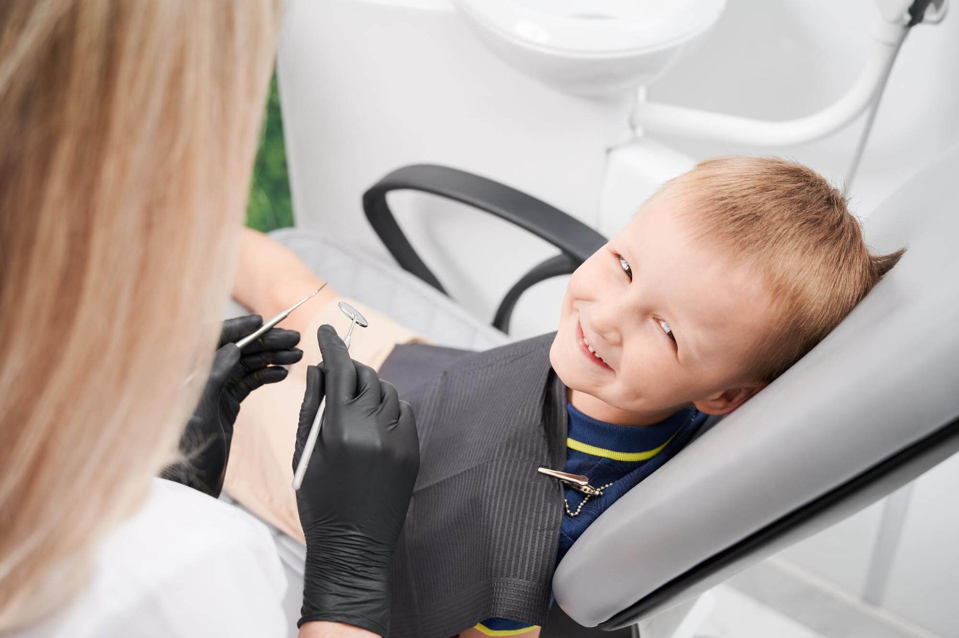 Cheerful little boy sitting in dental chair