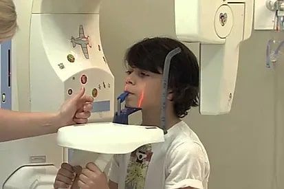 A young boy is getting an x-ray of his teeth.