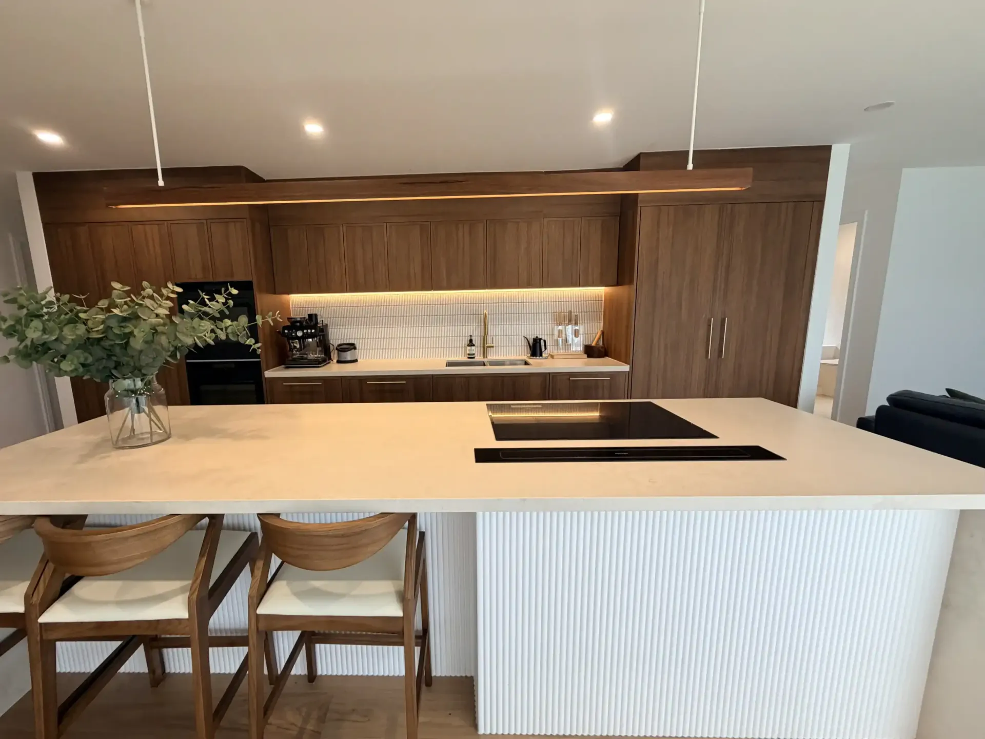 White kitchen cabinets installed, with a window and unfinished walls.