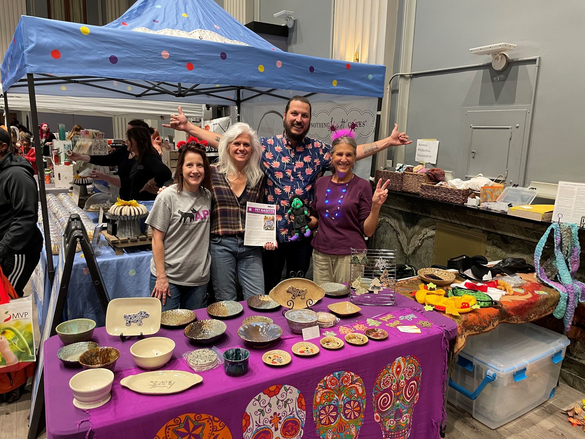 A group of people are standing around a table with plates and bowls on it.