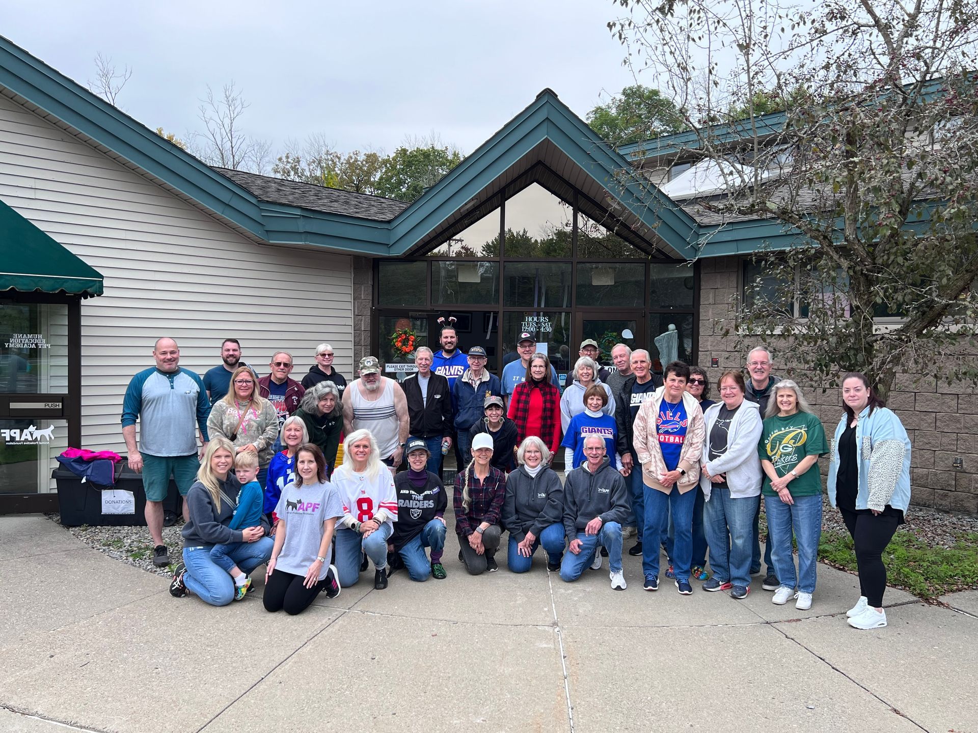 A large group of people are posing for a picture in front of a building.