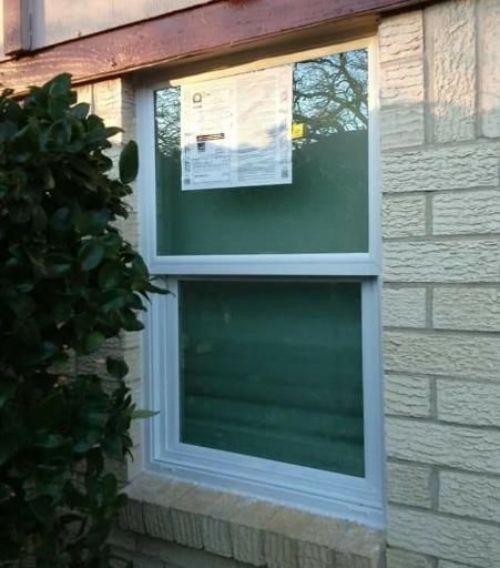 A worker carefully installing an awning on the house wall to provide shade over the terrace window.