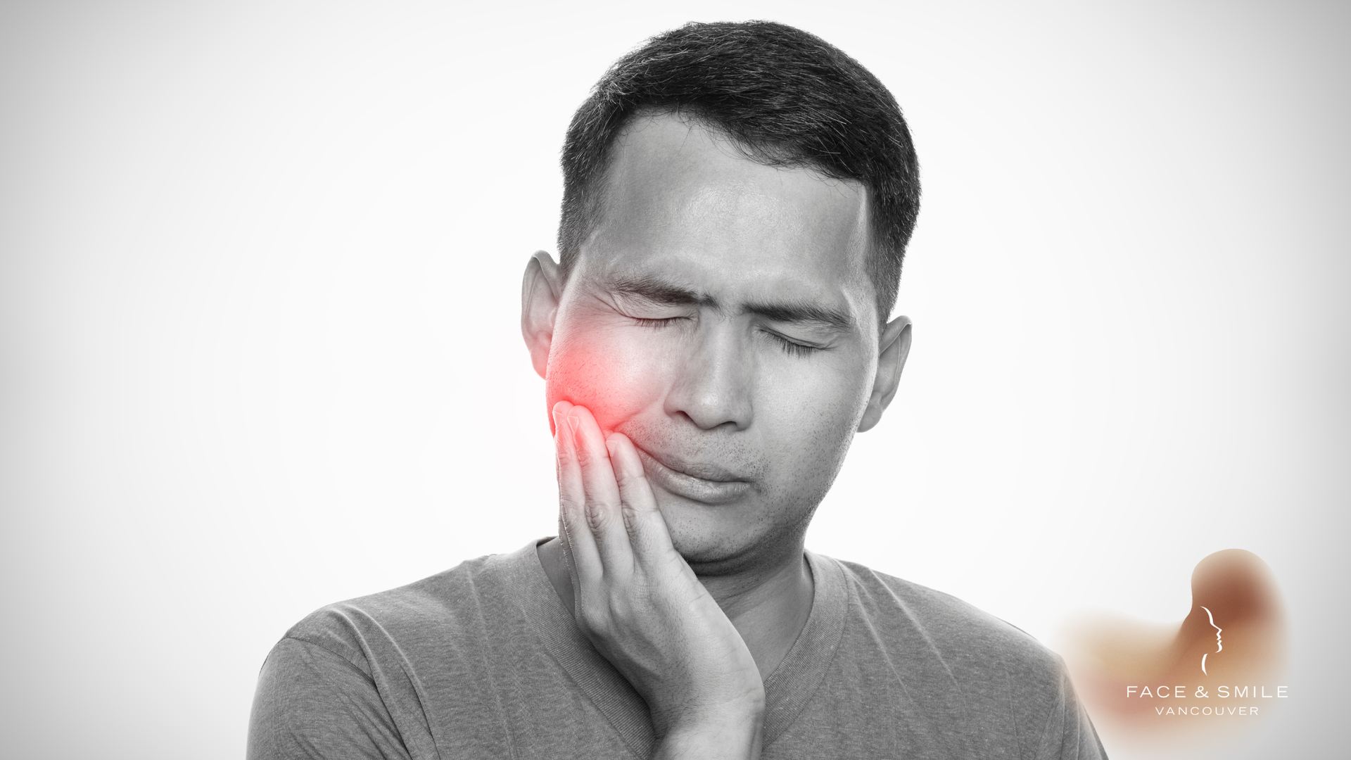 Man with hand on cheek, face in pain, red highlight on jaw.