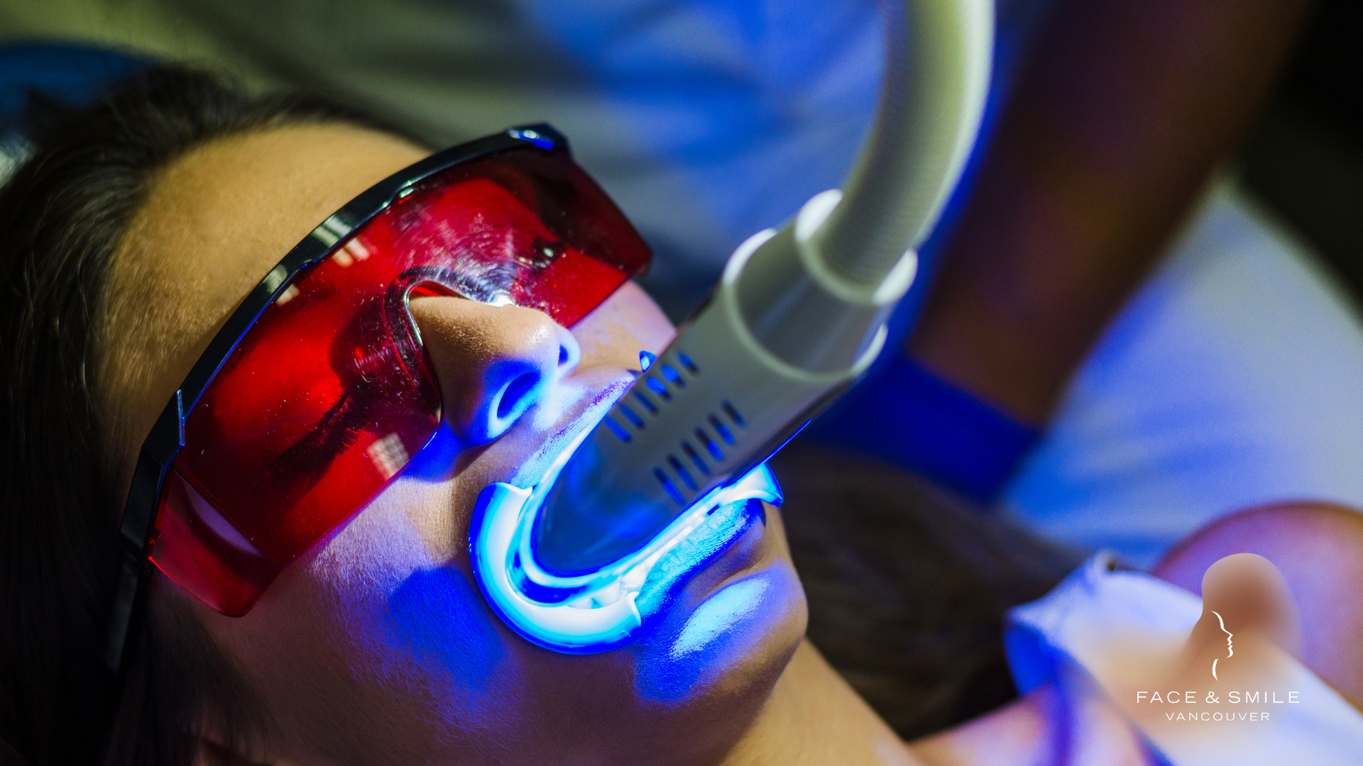 A woman is getting a teeth whitening treatment at a beauty salon.