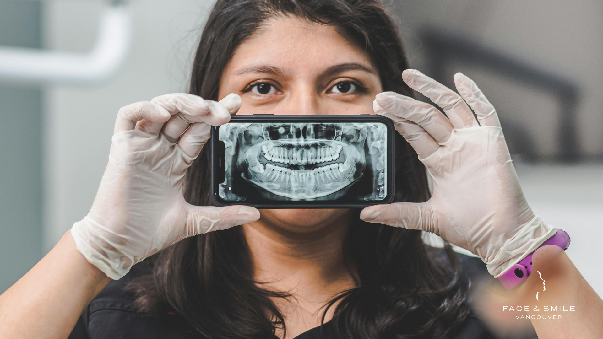 A woman is holding a cell phone in front of her face.