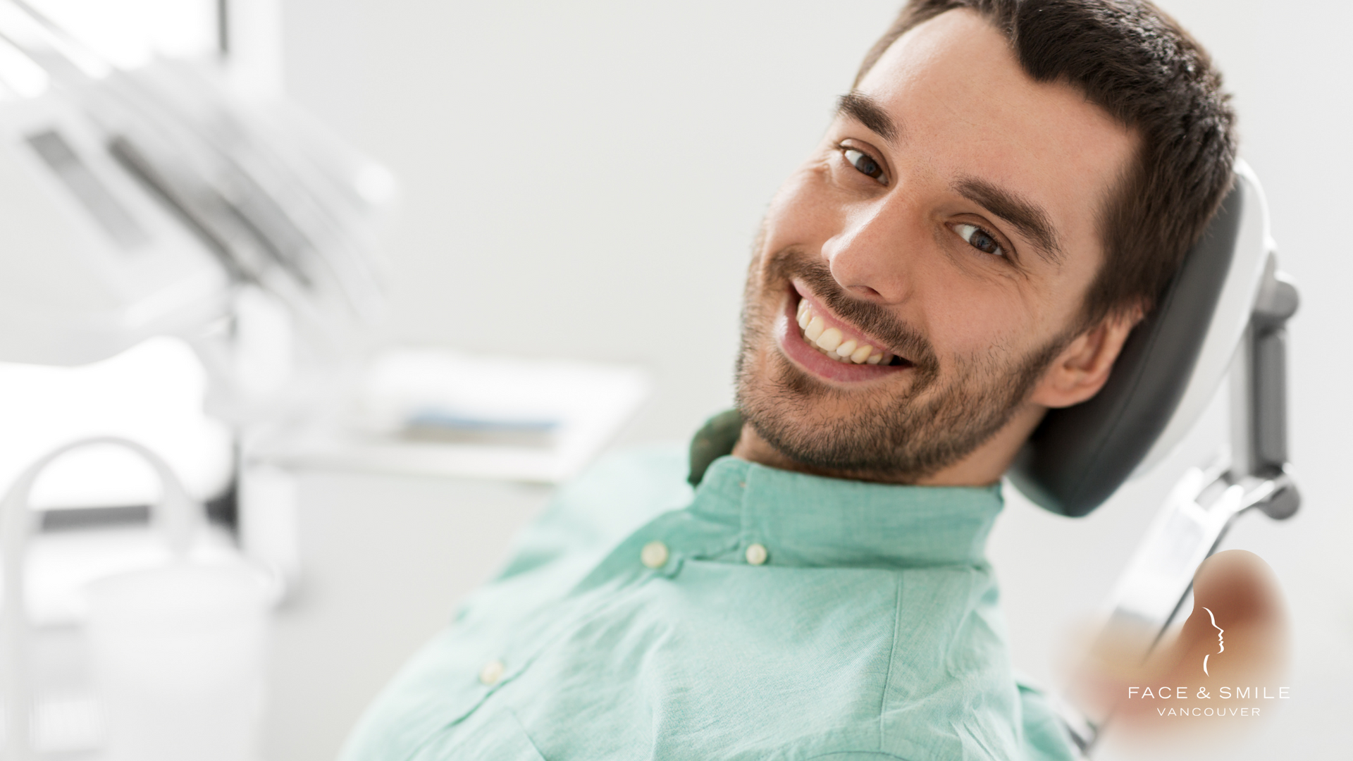 A man is smiling while sitting in a dental chair.