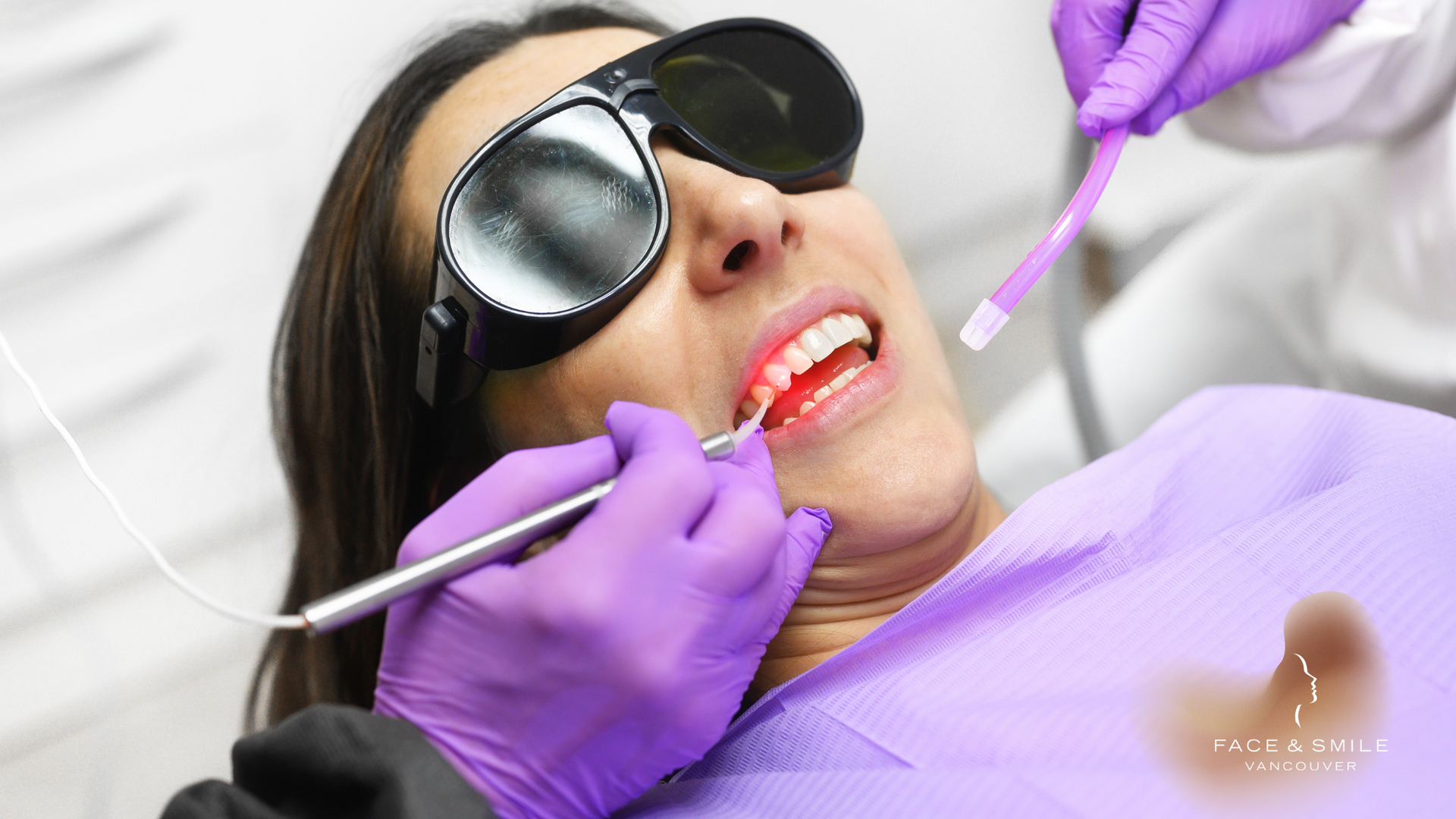 A woman is getting her teeth examined by a dentist.