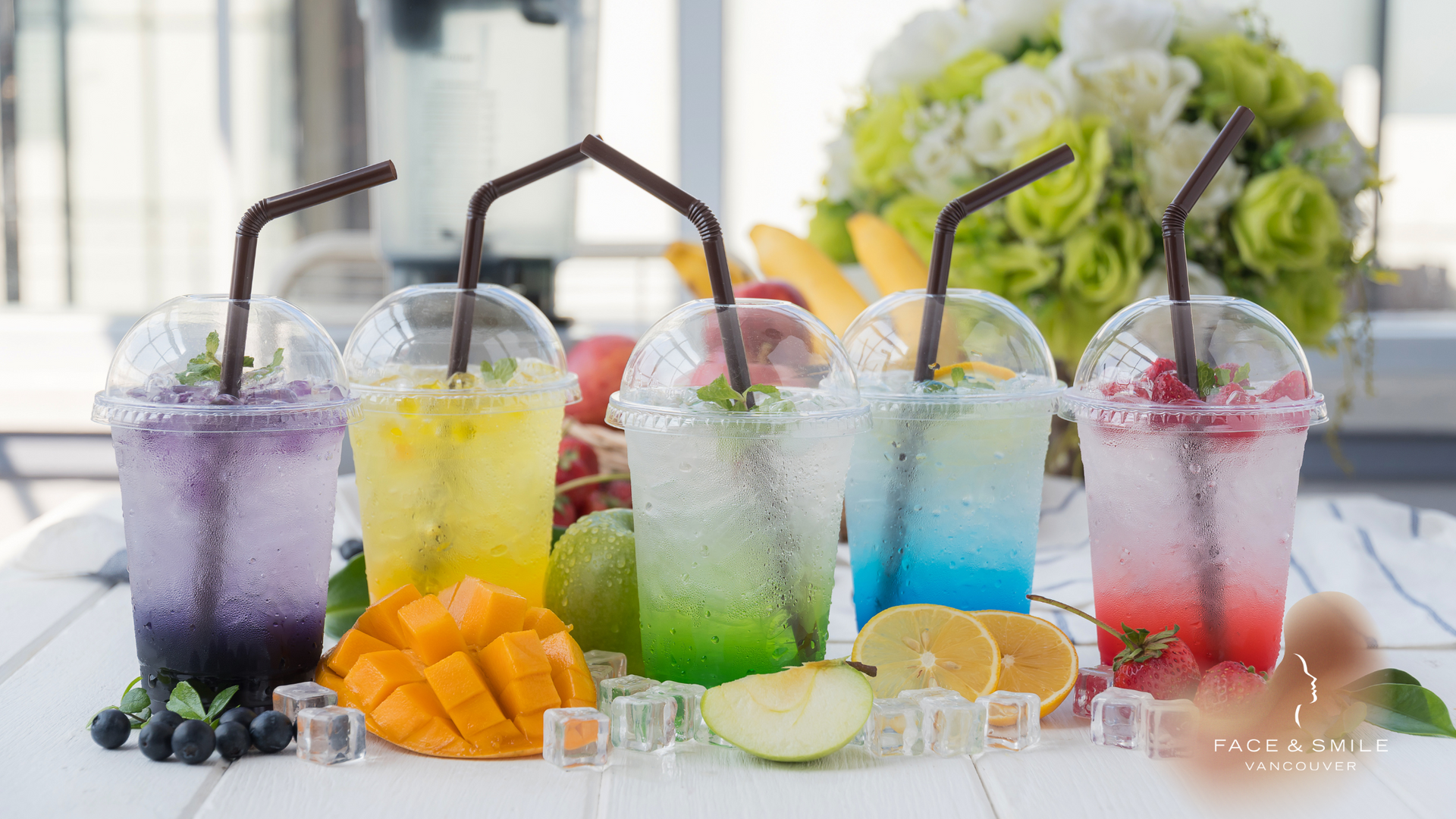 There are many different types of drinks in plastic cups on the table.